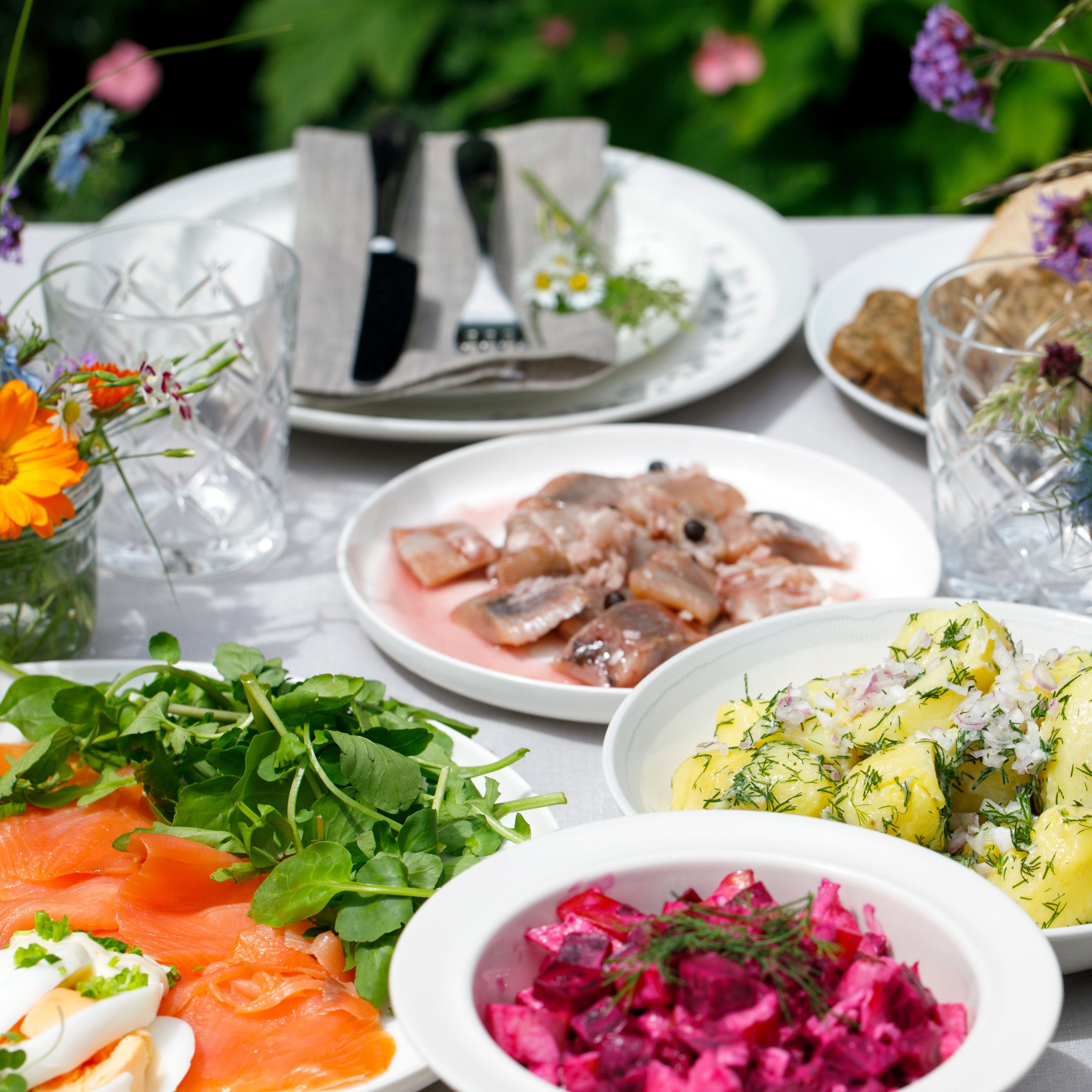 Scandinavian midsummer feast with potato salad, herring, salmon